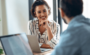 Shot of smart businesspeople working together with laptop while talking in the coworking place.